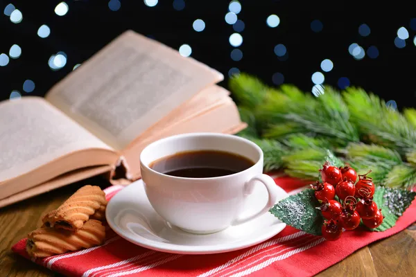 Komposition von Buch mit Tasse Kaffee und Weihnachtsdekoration auf Tisch auf dunklem Hintergrund — Stockfoto