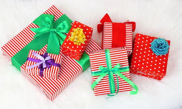 Many colorful presents with luxury ribbons  on color carpet background — Stock Photo, Image