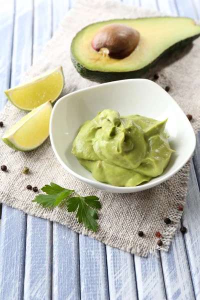 Fresh guacamole in bowl on wooden table — Stock Photo, Image