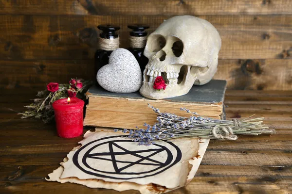 Foto conceptual de la magia del amor. Composición con cráneo, hierbas secas y vela sobre fondo de madera oscura — Foto de Stock