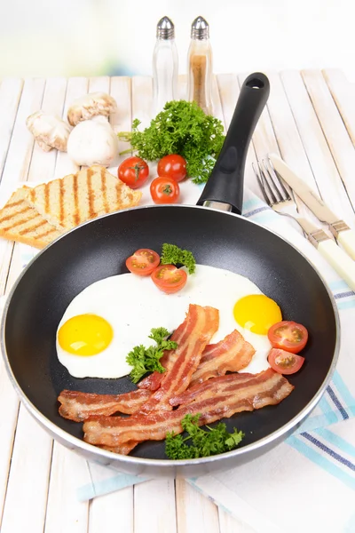 Яйця і бекон на сковороді на столі крупним планом — стокове фото