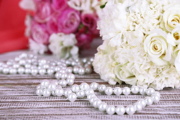Красивые свадебные букеты на столе на фоне ткани — стоковое фото
