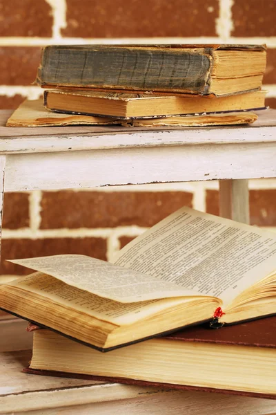 Boeken over houten ladder op kleur muur achtergrond — Stockfoto