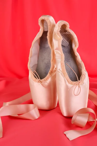 Ballet pointe schoenen op rode stof achtergrond — Stockfoto