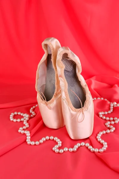 Ballet pointe schoenen op rode stof achtergrond — Stockfoto