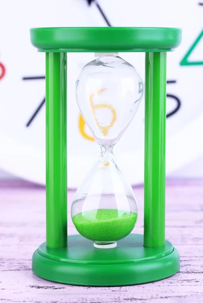 Hourglass and big clock on light background — Stock Photo, Image