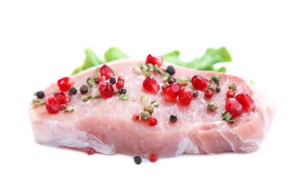 Raw meat steak with leaf lettuce, spices and pomegranate seeds, isolated on white — Stock Photo, Image