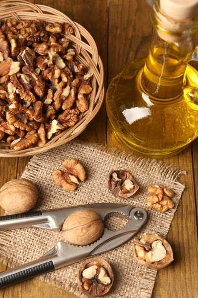 Walnut oil and nuts on wooden table — Stock Photo, Image