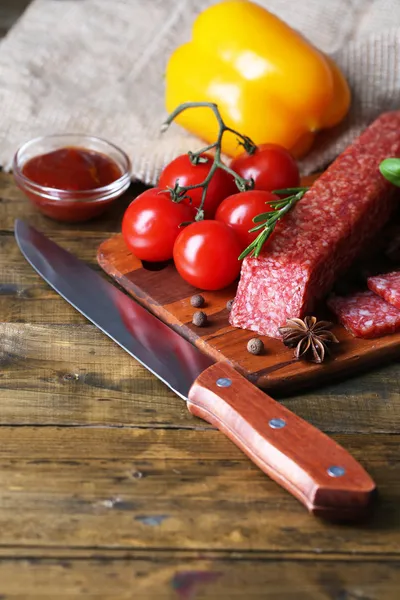 Saporito salame salsiccia e spezie su sfondo di legno — Foto Stock