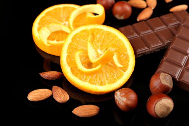 çikolata, turuncu ve siyah arka plan üzerine fındık