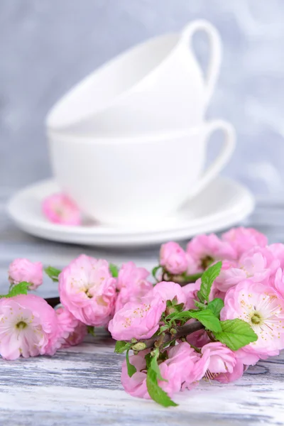 Beautiful fruit blossom in glass on table on grey background — Stock Photo, Image