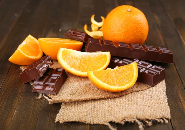 Čokoláda a pomeranč na dřevěný stůl — Stock fotografie