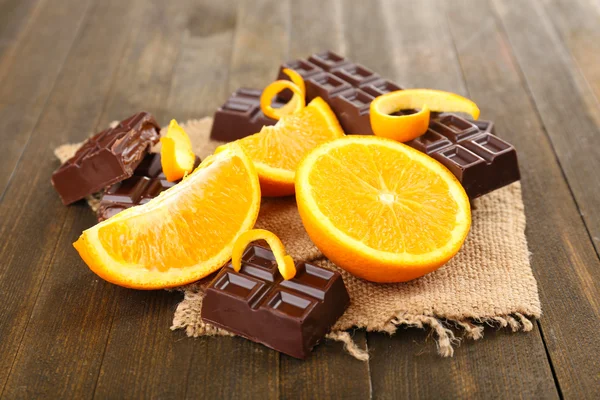 Čokoláda a pomeranč na dřevěný stůl — Stock fotografie