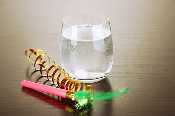 Glas med efervescent tablett i vatten med bubblor på träbord — Stockfoto