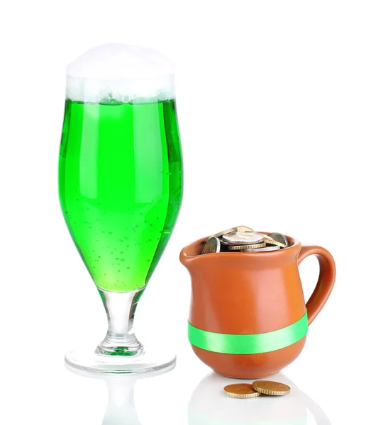 Glass of green beer and pitcher with coins isolated on white — Stock Photo, Image