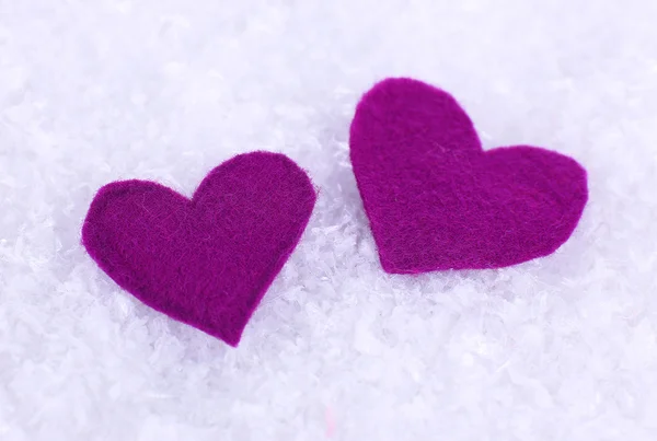 Pequeños corazones sentidos sobre fondo nevado — Foto de Stock