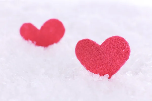 Pequeños corazones sentidos sobre fondo nevado — Foto de Stock