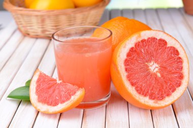 Ripe grapefruit with juice on table close-up clipart