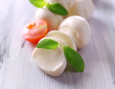 ahşap masa üstünde domates ve fesleğen ile lezzetli mozzarella peyniri