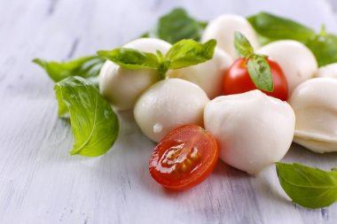ahşap masa üstünde domates ve fesleğen ile lezzetli mozzarella peyniri