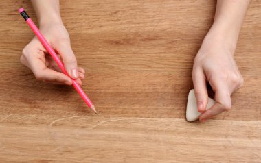 insan eli ile ahşap masa arka plan üzerinde kalem ve silme lastik