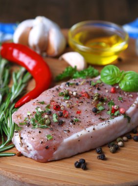 Otlar ve baharatlar ahşap arka plan üzerinde kesme tahtası üzerinde çiğ et biftek