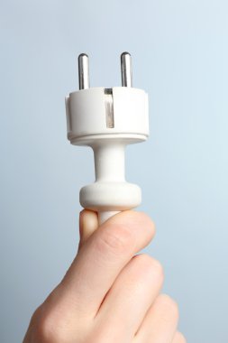 Mavi arkaplanda el ele tutuşan elektrik prizi