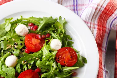 roka, domates, peynir mozzarella toplar ve ahşap zemin üzerinde plaka üzerinde susam ile yapılan yeşil salata