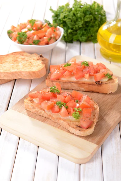 Deliciosa bruschetta con tomates en la tabla de cortar de cerca —  Fotos de Stock