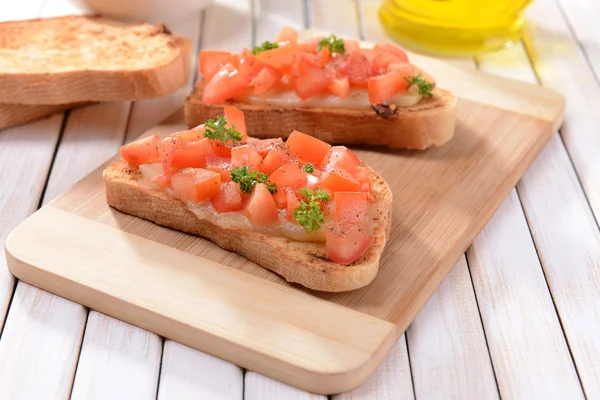 Kesme tahtasında domatesli lezzetli bruschetta.