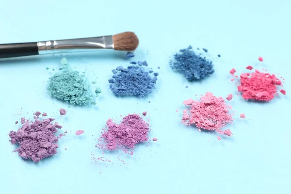Rainbow Crushed Lidschatten und professioneller Make-up Pinsel auf blauem Hintergrund — Stockfoto