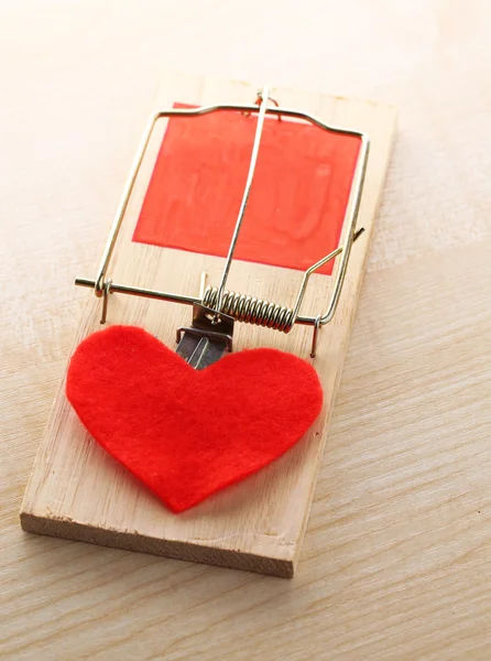 Mousetrap with heart on wooden background — Stock Photo, Image