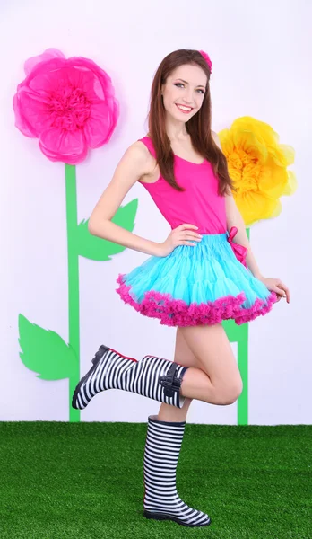 Schöne junge Frau im Minirock auf dekorativem Hintergrund — Stockfoto