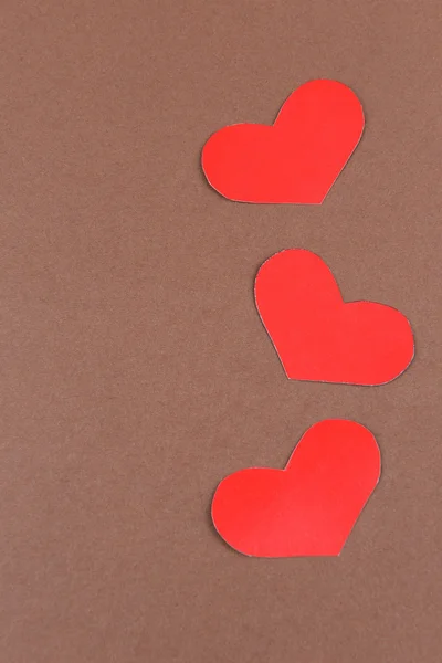 Paper hearts on brown background — Stock Photo, Image