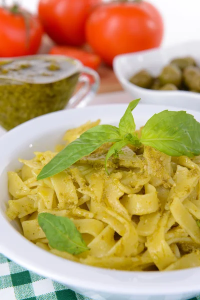 Läckra pasta med pesto på tallriken på bordet närbild — Stockfoto