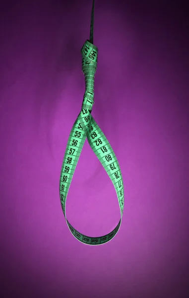 Tape measure noose on purple background - diet concept — Stock Photo, Image