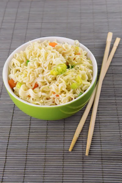 Macarrão instantâneo saboroso com legumes na tigela na mesa close-up — Fotografia de Stock