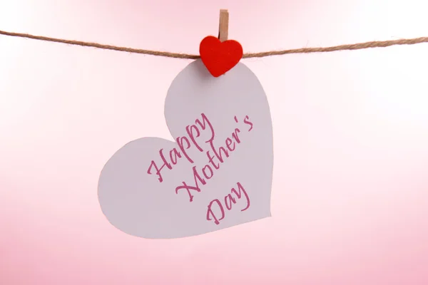 Feliz Dia das Mães mensagem escrita em papel coração sobre fundo rosa — Fotografia de Stock