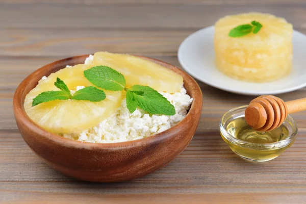 Tigela de queijo cottage saboroso com abacaxi na mesa de madeira — Fotografia de Stock