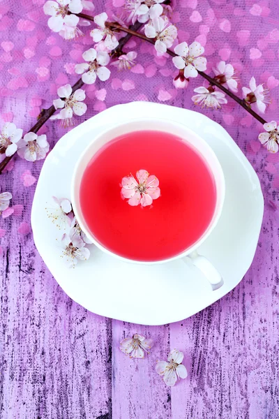 Fragrant tea with flowering branches on wooden table close-up — Stock Photo, Image