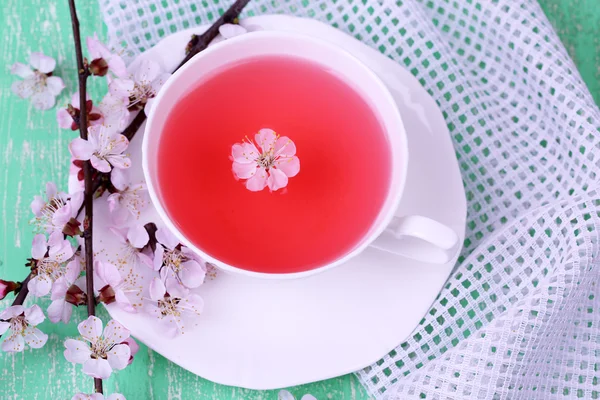 Ароматний чай з квітучими гілками на дерев'яному столі крупним планом — стокове фото