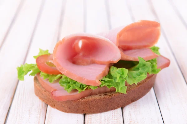 Delicioso sanduíche com alface e presunto na mesa close-up — Fotografia de Stock
