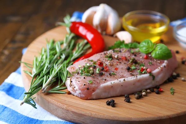 Filete de carne cruda con hierbas y especias en la tabla de cortar, sobre fondo de madera —  Fotos de Stock