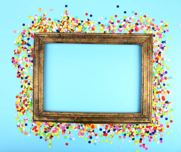 Photoframe with confetti on blue background — Stock Photo, Image