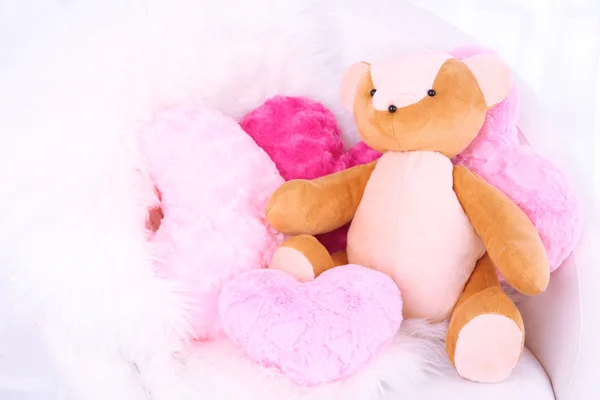 Медвежья игрушка с подушками на кресле в номере — стоковое фото