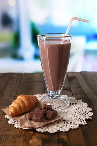 Leche de chocolate en vaso, sobre mesa de madera, sobre fondo brillante — Foto de Stock