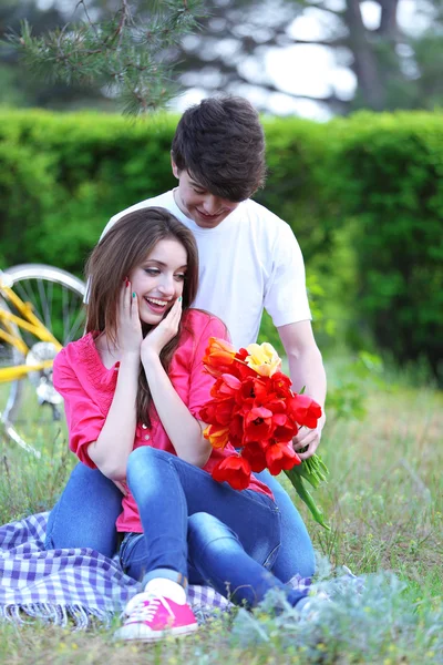 Jeune couple assis dans le parc — Photo