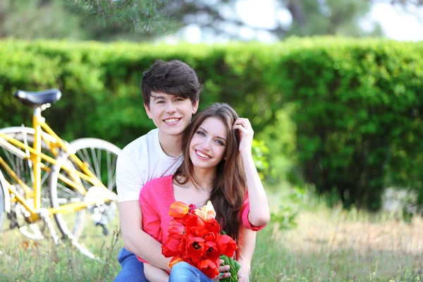 Pareja joven sentada en el parque con bicicletas —  Fotos de Stock