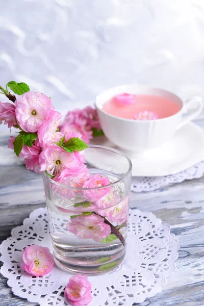 Mooie fruit blossom in glas op tafel op grijze achtergrond — Stockfoto