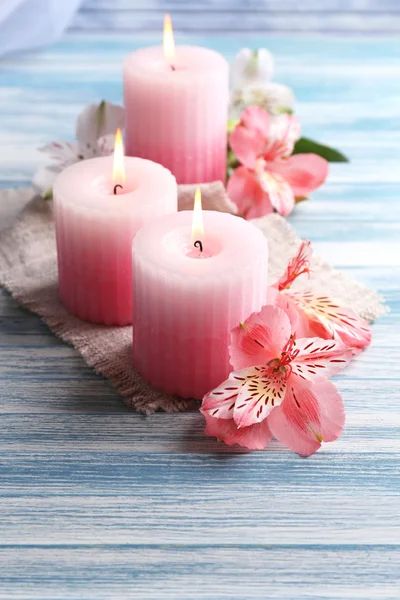 Schöne Kerzen mit Blumen auf Holzgrund — Stockfoto